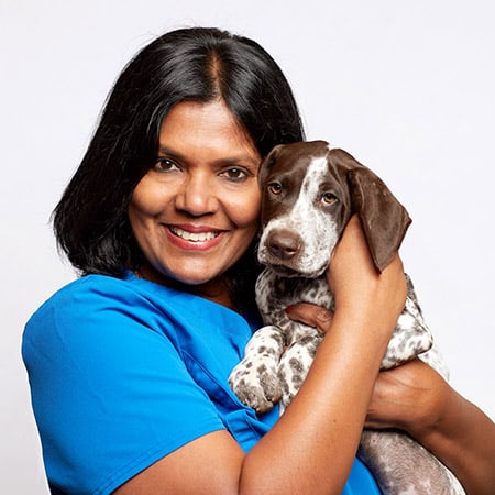 Dr. Nilanthi Vipuli Kulasekara Veterinarian at Urgent Pet Doctor Headshot holding puppy